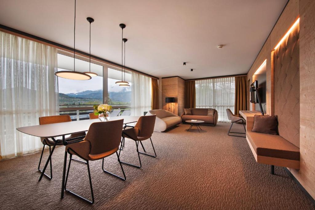 ein Wohnzimmer mit einem Tisch und Stühlen in der Unterkunft Rikli Balance Hotel – Sava Hotels & Resorts in Bled