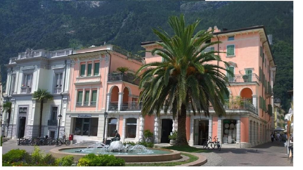 palma di fronte a un edificio con fontana di Villa Aranci Downtown a Riva del Garda