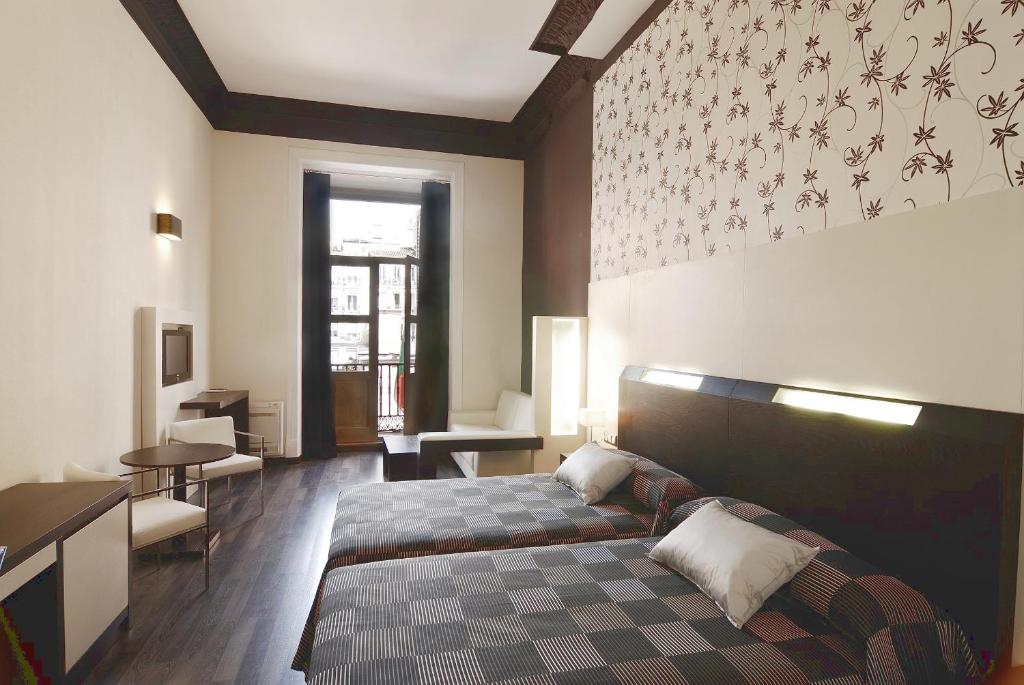 um quarto com uma cama e um sofá em Alhambra Suites em Madrid