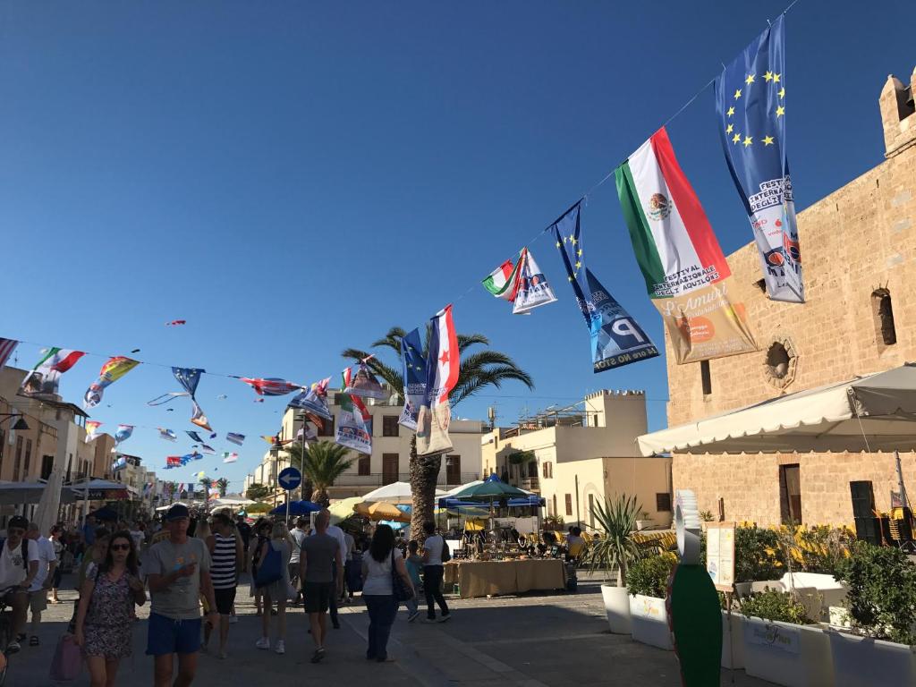 サン・ヴィート・ロ・カーポにあるLa terrazza nel Bluの旗を掲げて歩く人々