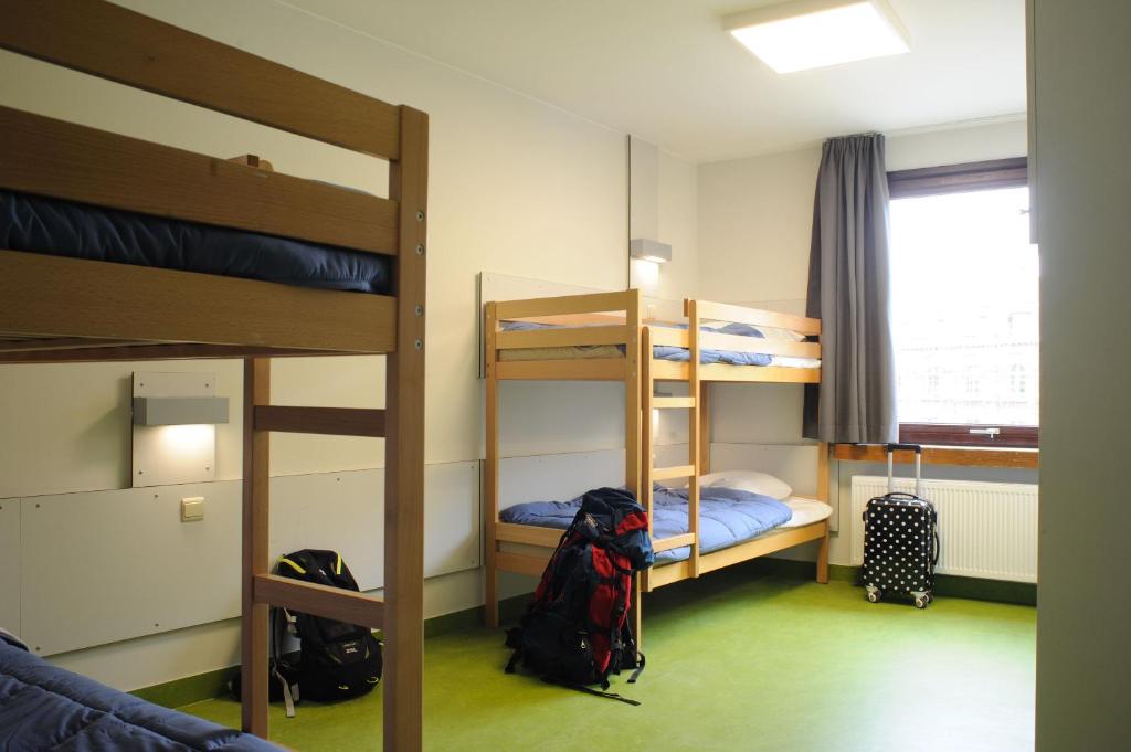 um quarto com 2 beliches e uma mochila em Hostel Bruegel em Bruxelas