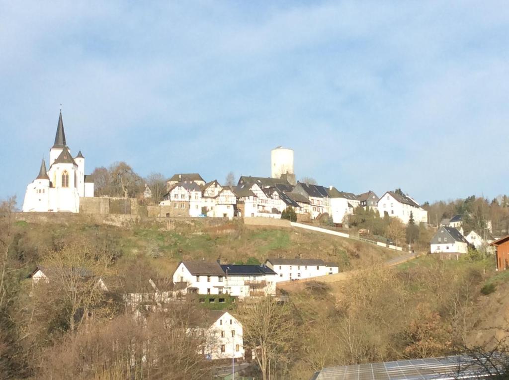 een klein dorpje met een kerk op een heuvel bij Gästehaus Im Tal 18 in Hellenthal