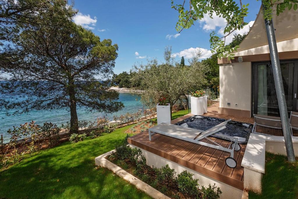 a house with a deck with a view of the water at Villas Bellevue Plava Laguna in Poreč