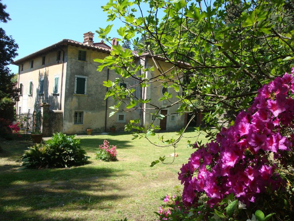 an old house with purple flowers in front of it at Bed & Breakfast Villa Masini-Luccetti in Pietrasanta