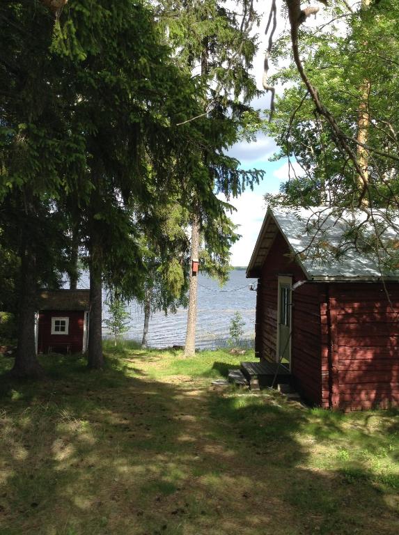 una pequeña cabaña junto a un cuerpo de agua en Svens Stuga en Burträsk