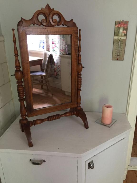 a mirror on top of a dresser with a candle at Domsjö Apartment in Örnsköldsvik