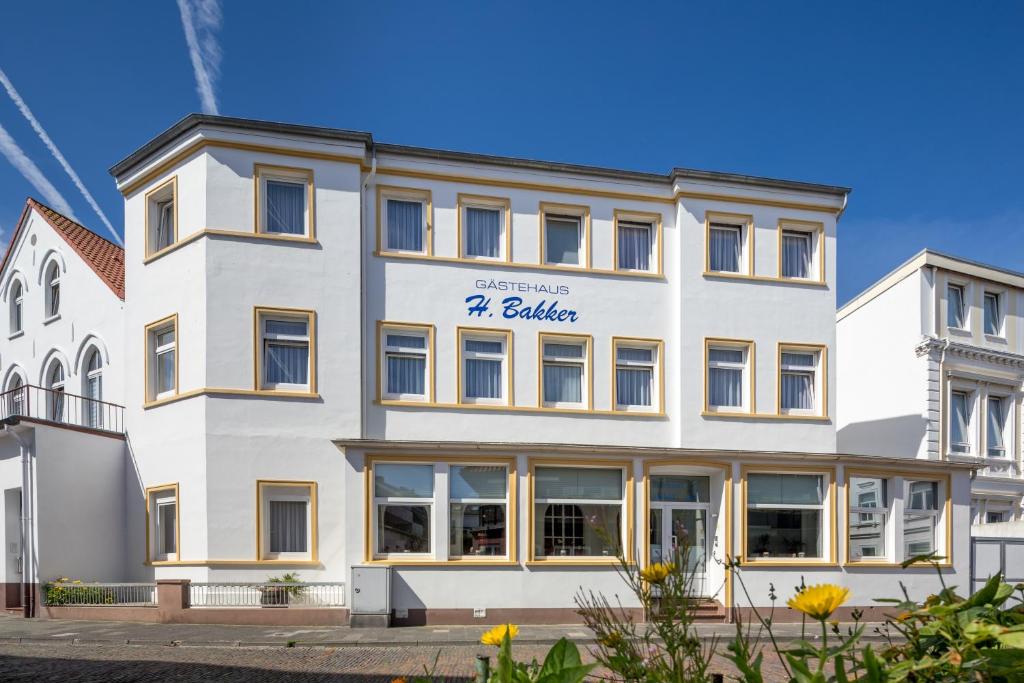 een wit gebouw met een bord waarop staat: galleria bij Gästehaus Bakker in Norderney