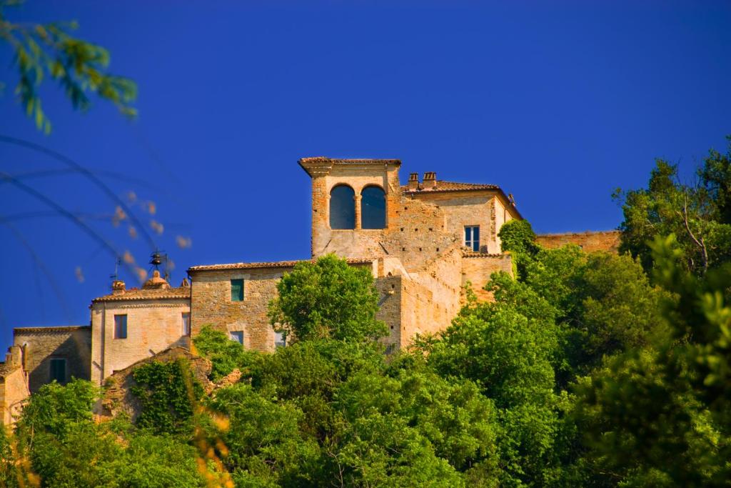 un vecchio edificio che si trova sopra alcuni alberi di B&B Borgo Marano a Cupra Marittima