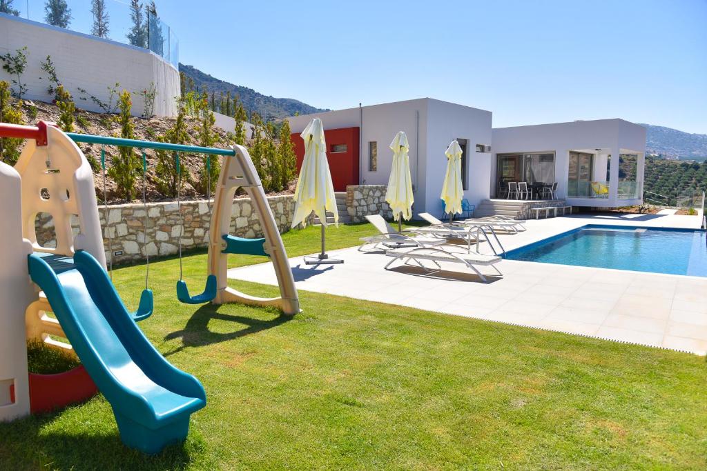 un complexe avec une piscine avec un toboggan et une aire de jeux dans l'établissement Sea View Villas, à Agia Pelagia