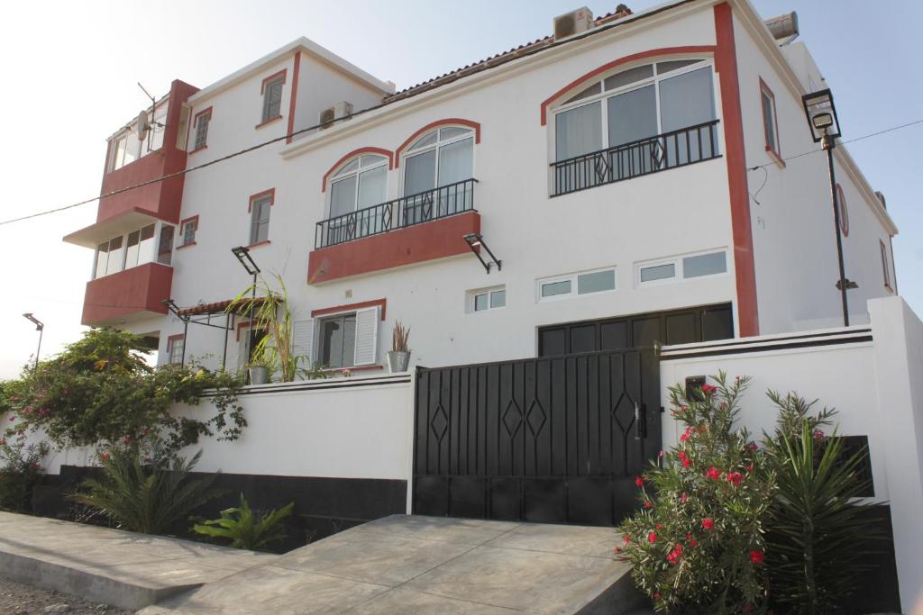 une maison blanche avec une porte noire dans l'établissement Yria Residencial, à Porto Novo