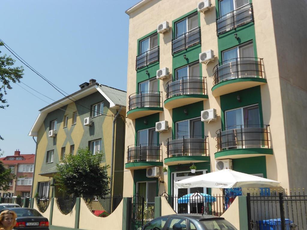 a tall building with balconies and an umbrella in front of it at Green House 2 in Eforie Nord
