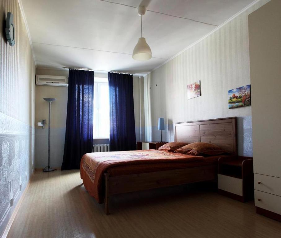 モスクワにあるApartment Nice on Presnenskiy Valのベッドルーム1室(青いカーテン付きの大型ベッド1台付)