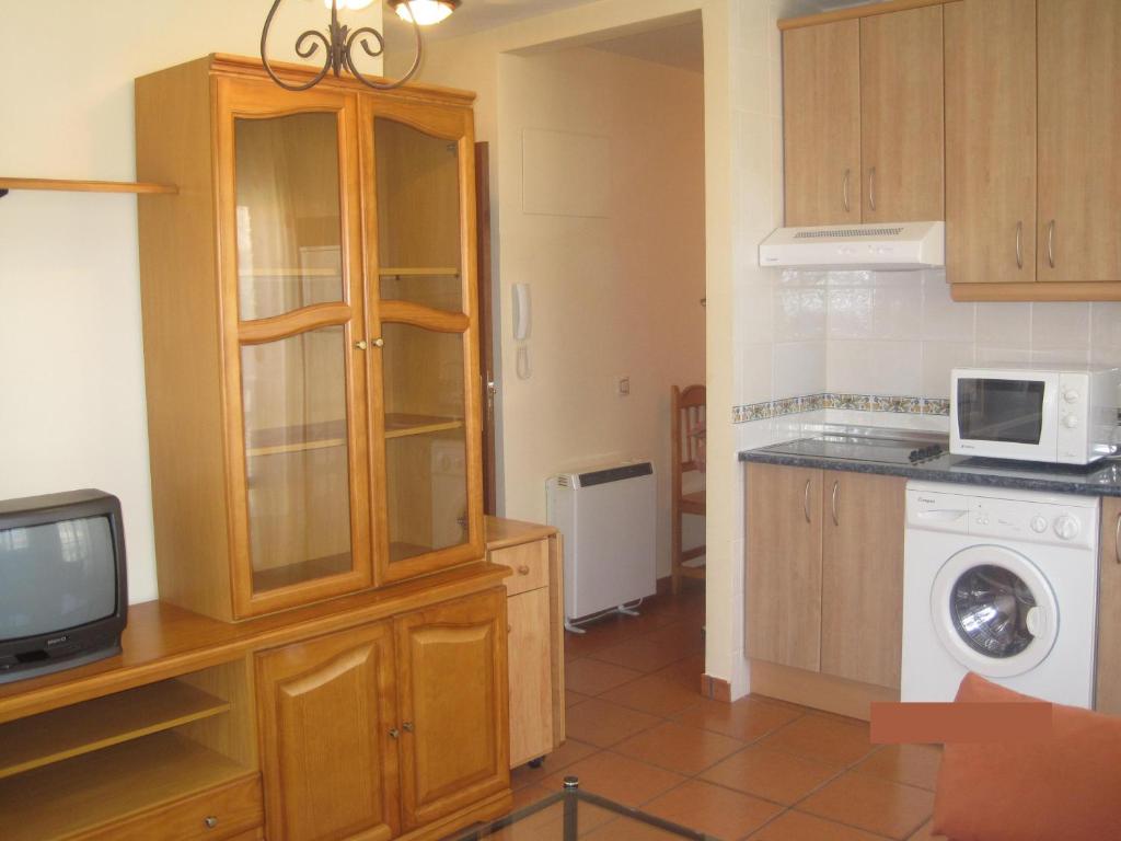 cocina con lavadora y microondas en Apartamento Rural Lobo, en Ucero