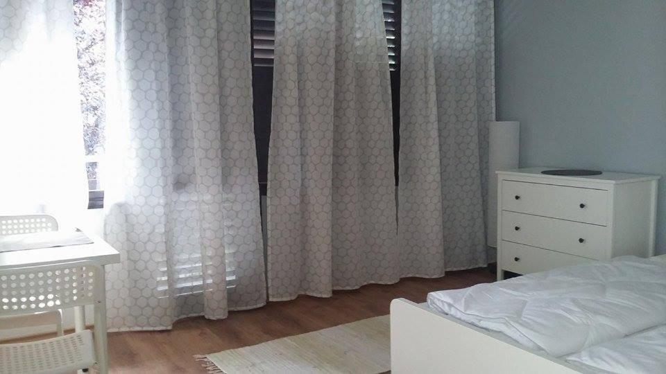 シオーフォクにあるMobius Hausのベッドルーム(白いカーテン、ベッド1台、ドレッサー付)