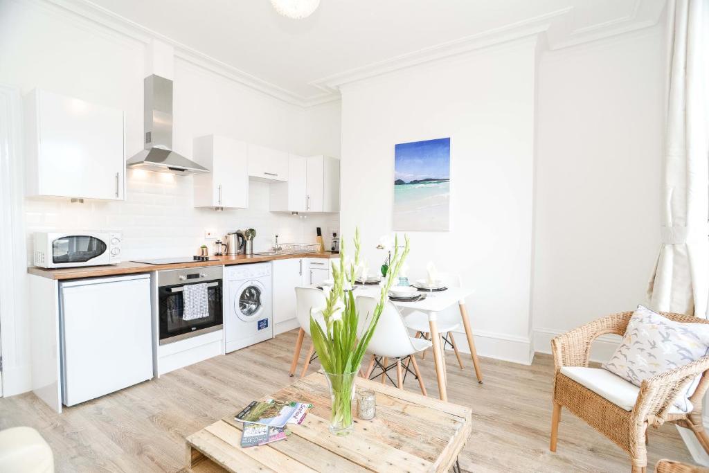 a kitchen and living room with a table and chairs at Modern Central Apartment in Aberdeen