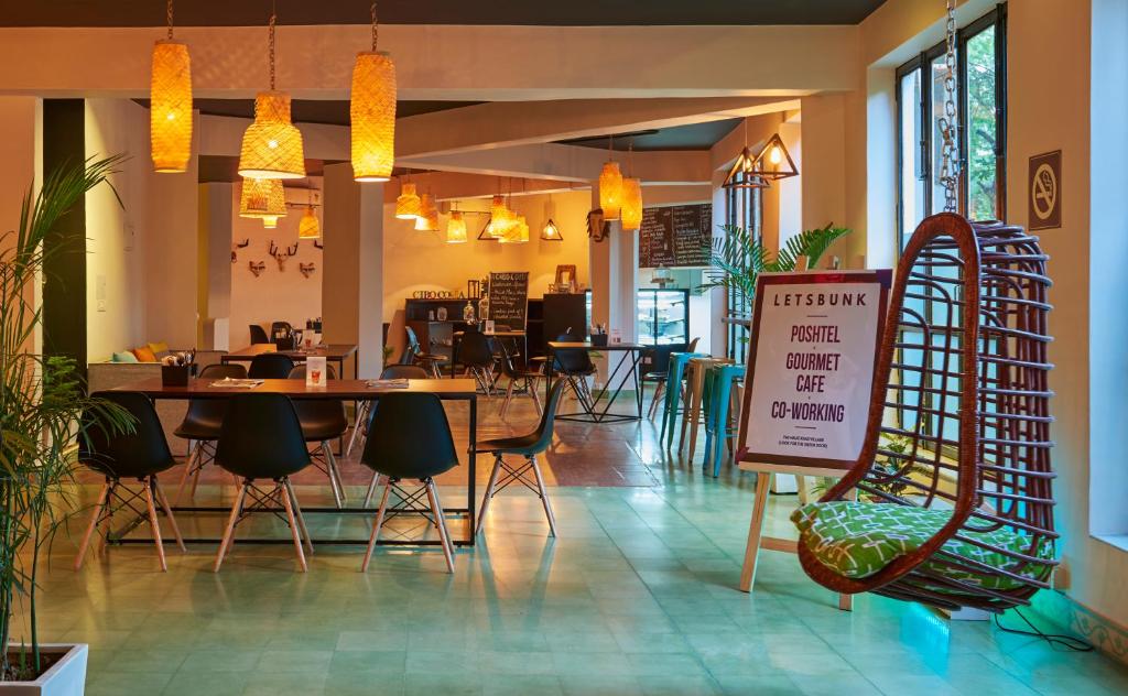 a restaurant with a table and chairs and a sign at LetsBunk Poshtel & Suites in New Delhi