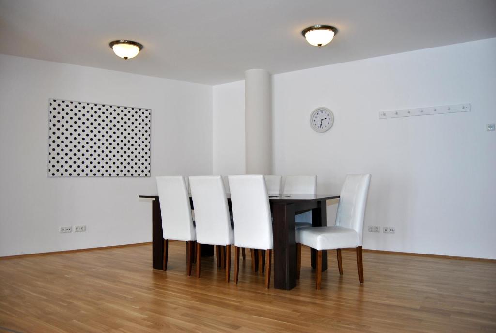 a dining room with a table and white chairs at Vailo City Suites Leipzig Altstadt in Leipzig