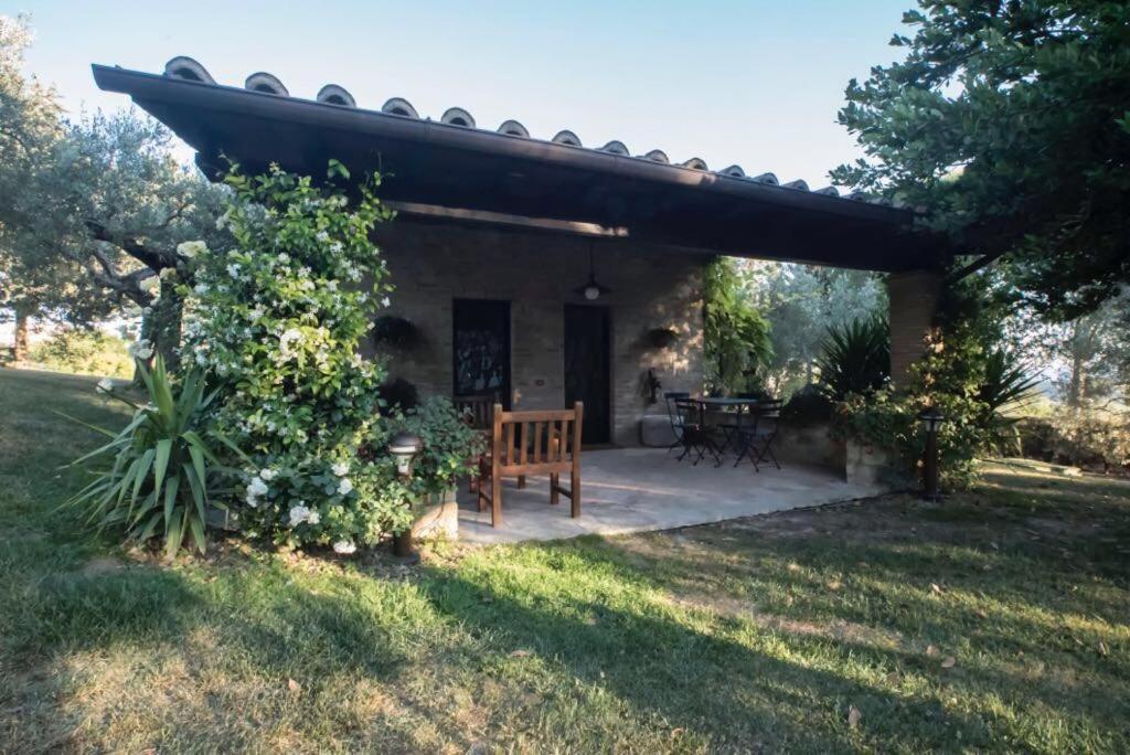 patio z ławką i stołem na dziedzińcu w obiekcie Dimora Borgogni: Country House w mieście Perugia