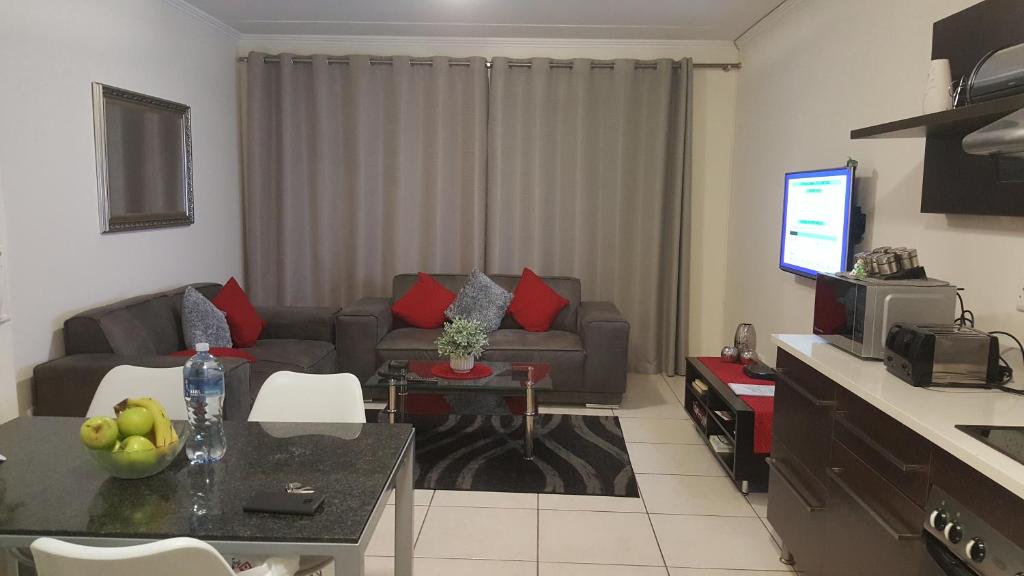 a living room with a couch and a table at Strelitzia Apartment in Edenvale