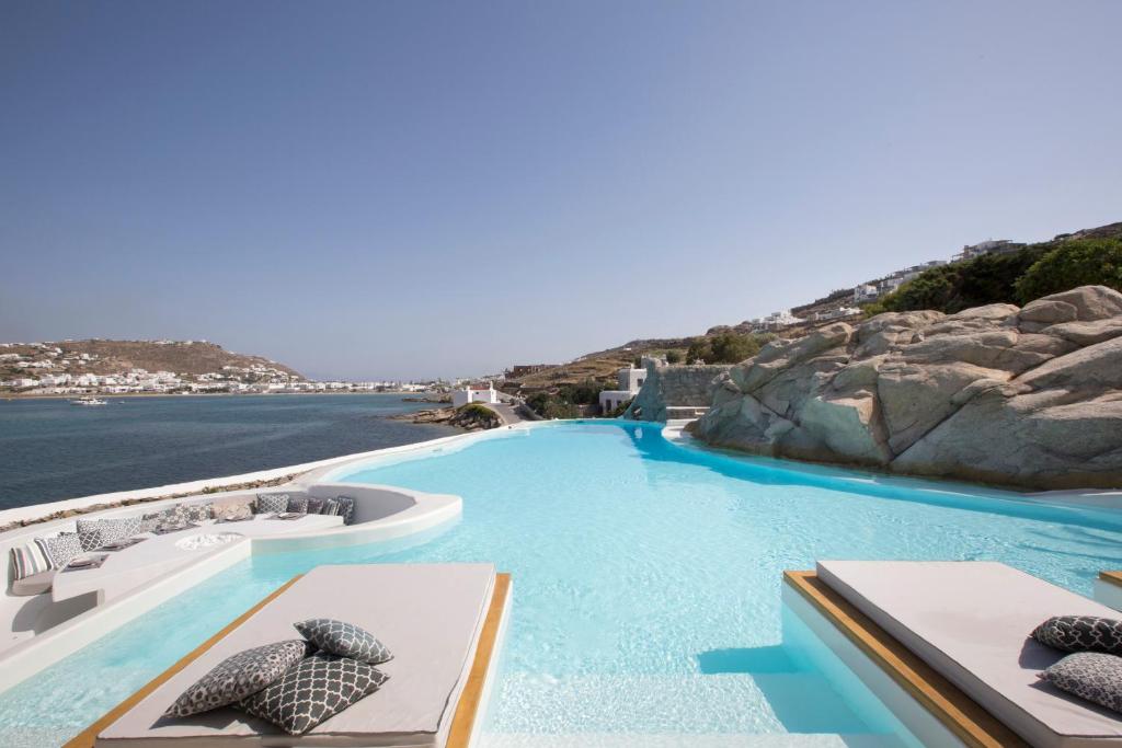 a beach with a pool and a large swimming pool at Dreambox Mykonos Suites in Ornos