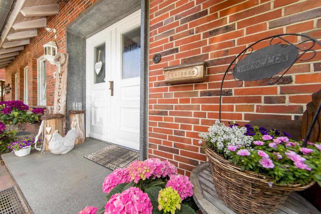 eine Veranda mit Blumen in Körben neben einer Tür in der Unterkunft Ferienhof Heins in Undeloh