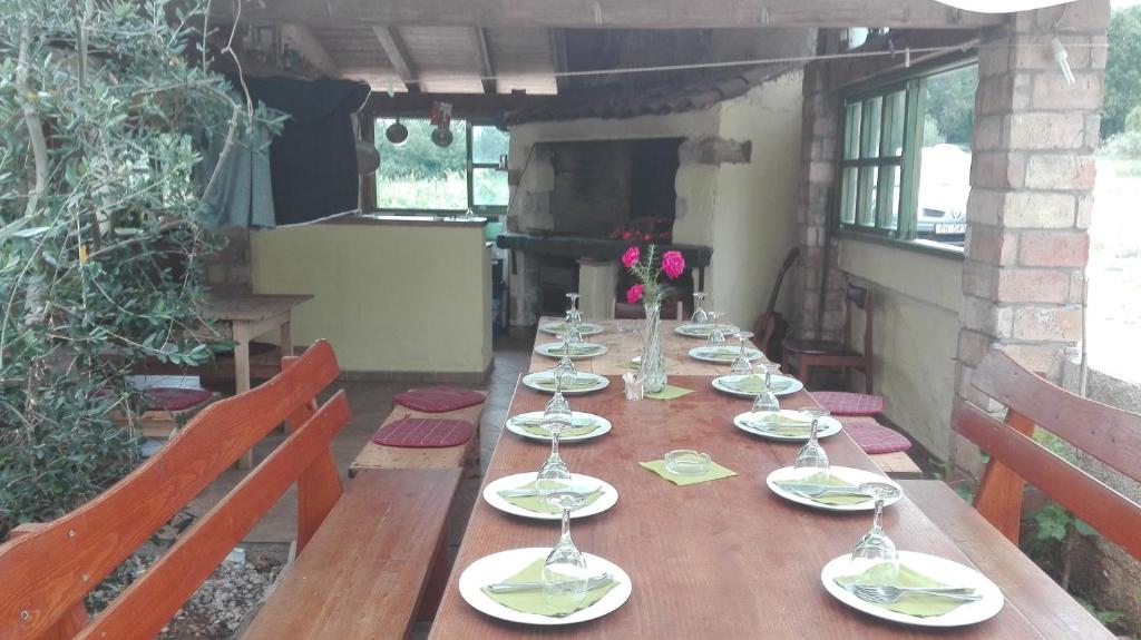 a long wooden table with plates and wine glasses at Guesthouse Porec in Poreč