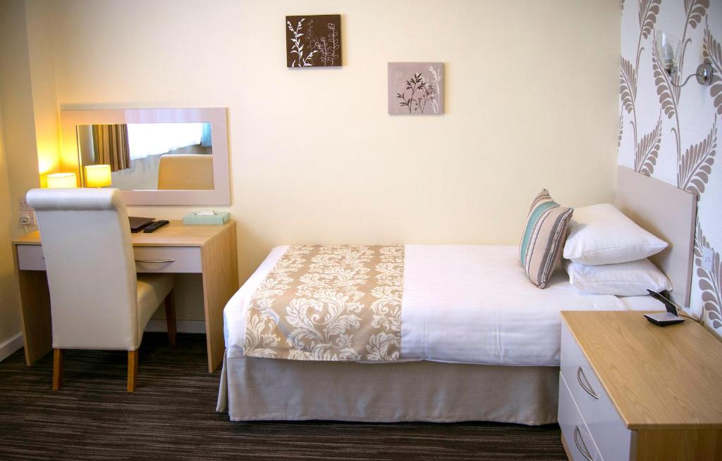 Una cama o camas en una habitación de Biarritz Hotel