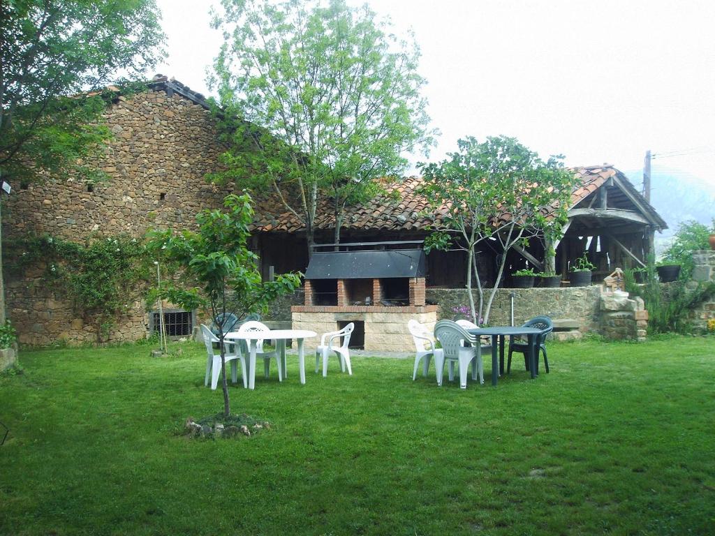 un groupe de tables et de chaises devant un bâtiment dans l'établissement Casa Rural Josefina, à Aliezo