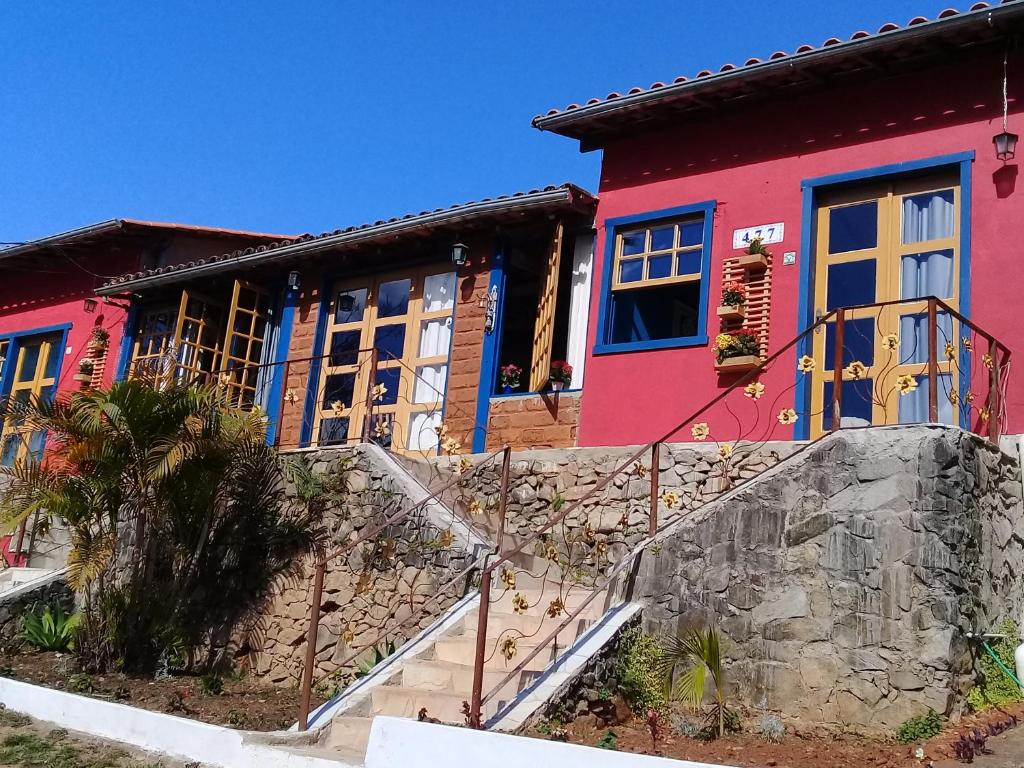 a colorful house with stairs in front of it at Pousada Nascer do Sol in Tiradentes