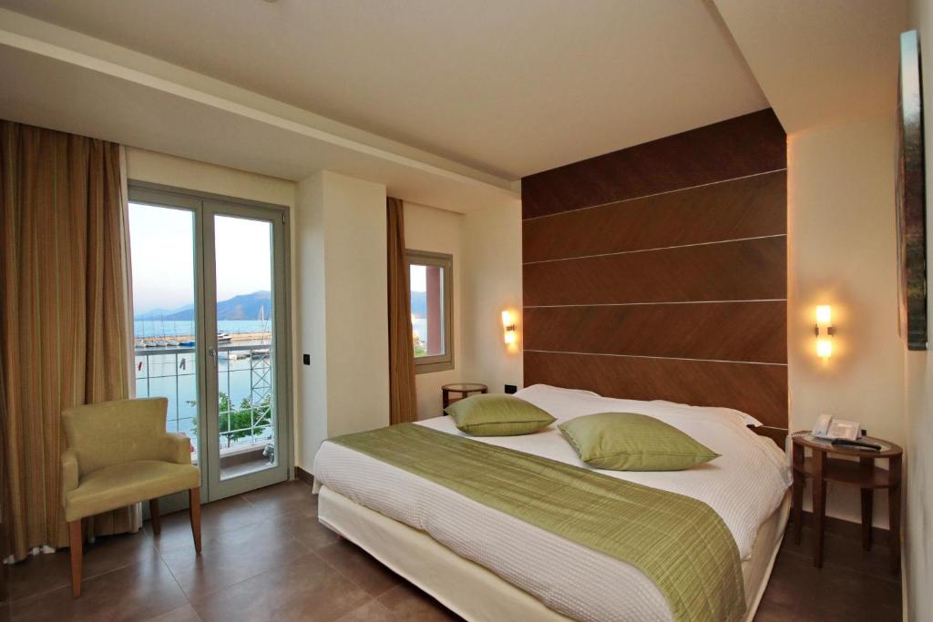 a bedroom with a large bed and a balcony at Astros Beach Boutique Hotel in Paralio Astros