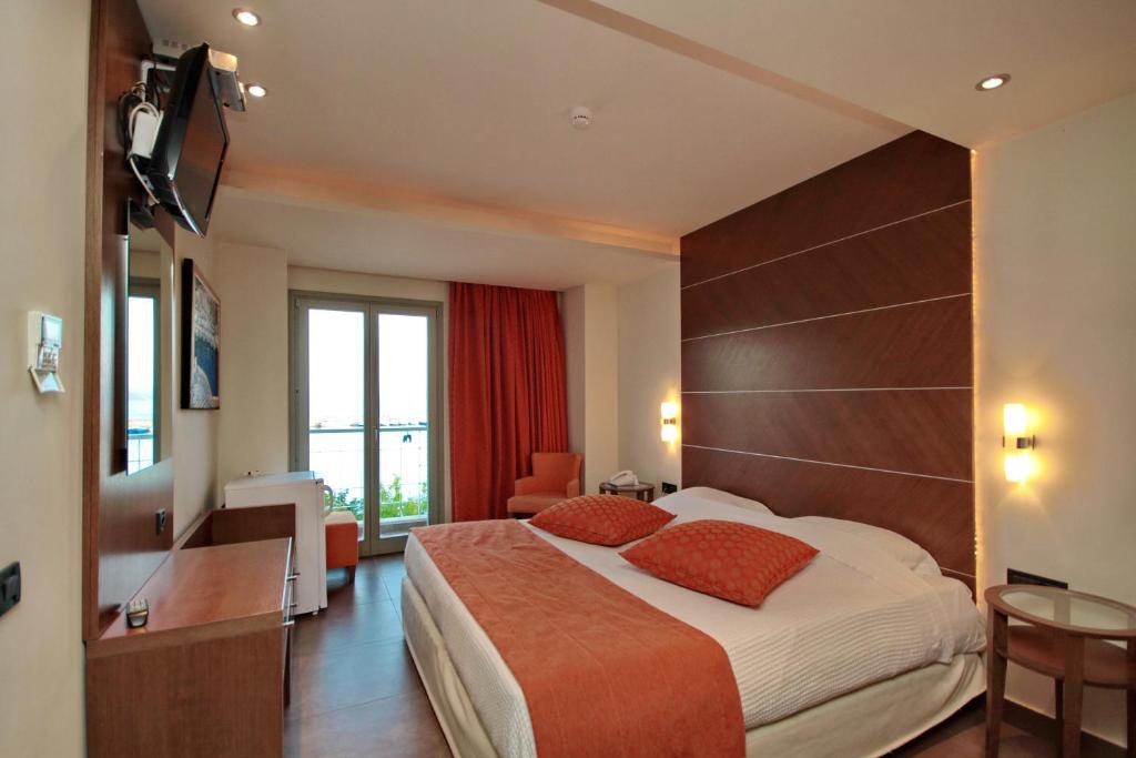 a hotel room with a large bed and a television at Astros Beach Boutique Hotel in Paralion astros