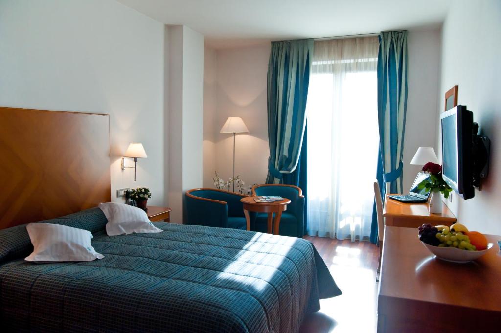una habitación de hotel con una cama y una mesa con un bol de fruta en Hotel Beyfin, en Cluj-Napoca