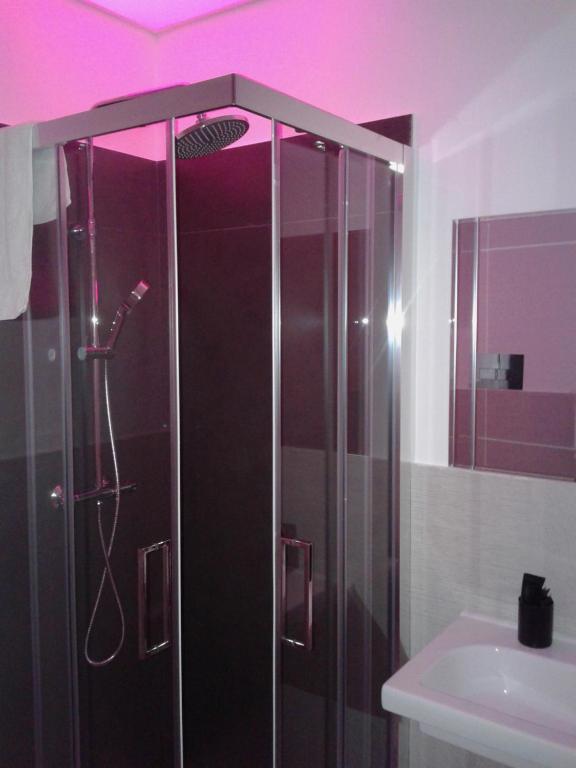 a bathroom with a shower with a sink and purple lighting at I Gelsomini in Melfi