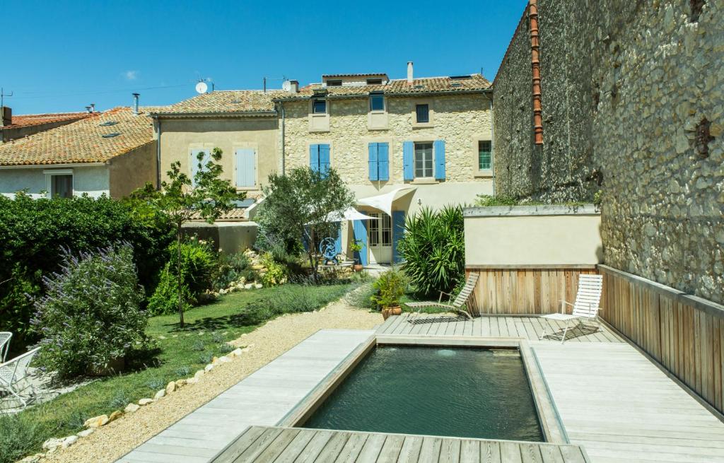 a swimming pool in a garden next to a building at La Maison des Vendangeurs 2 in Fleury