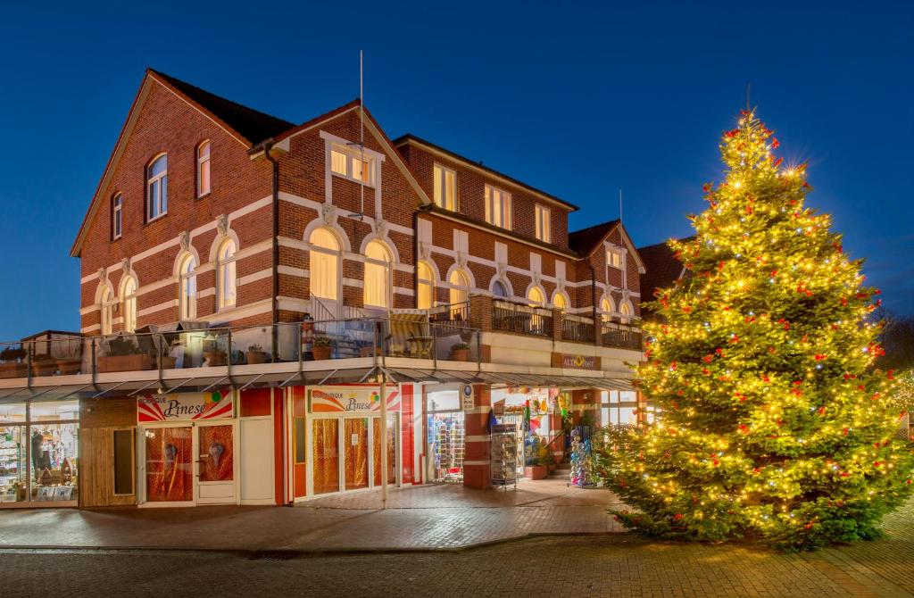 uma árvore de Natal em frente a um edifício em Appartementhaus Alte Post em Langeoog