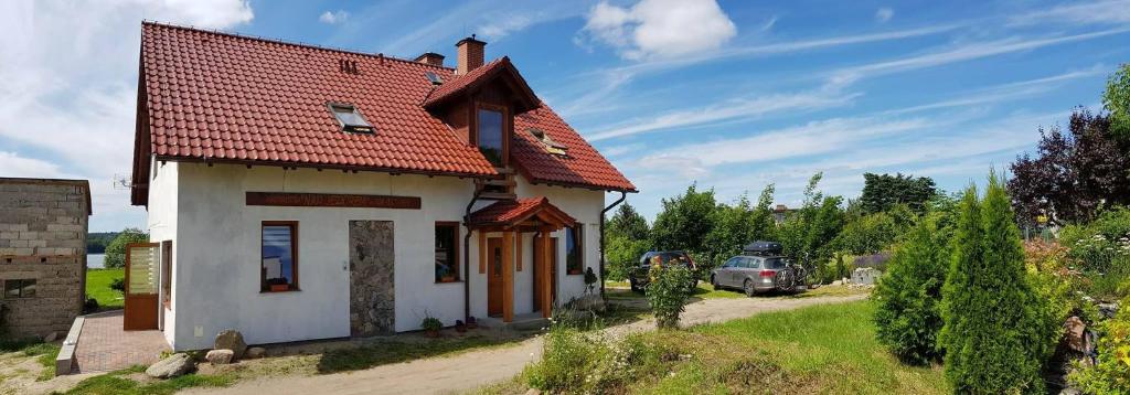 une petite maison blanche avec un toit rouge dans l'établissement Nad Jeziorem, à Charzykowy