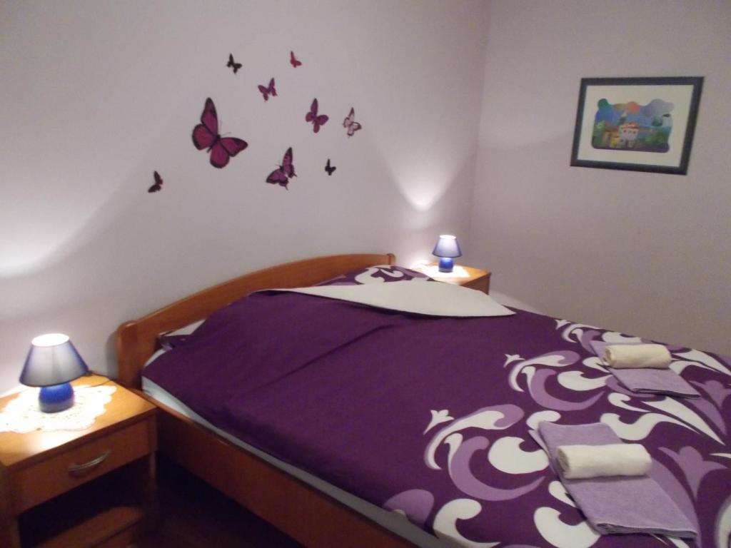 Un dormitorio con una cama morada con mariposas en la pared en Apartments Sara en Labin