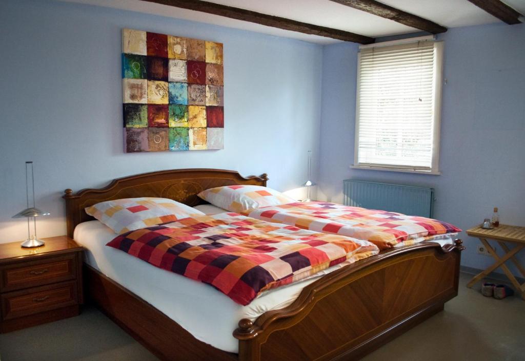 a bedroom with a bed with a plaid blanket on it at Gästezimmer der Adler Wirtschaft in Hattenheim