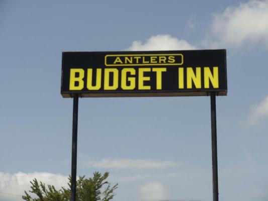 una señal para una posada económica en dos postes en Antlers Budget Inn, en Antlers