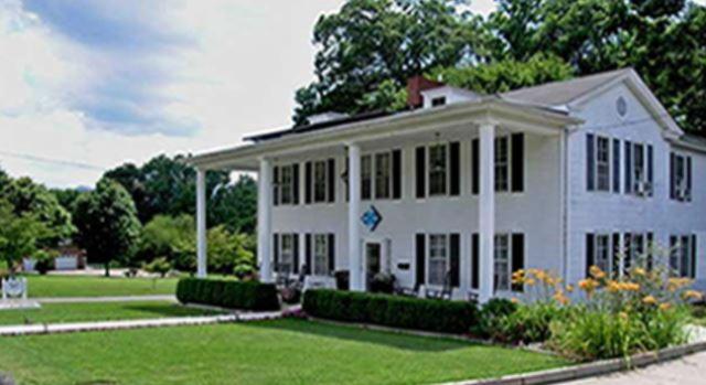 una gran casa blanca con césped y árboles en Terrell House B&B, en Burnsville