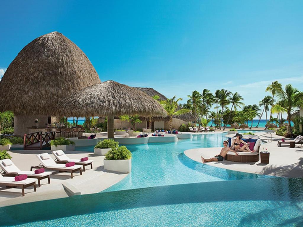 een weergave van een zwembad van het resort met mensen op stoelen bij Secrets Cap Cana Resort & Spa - Adults Only - All Inclusive in Punta Cana