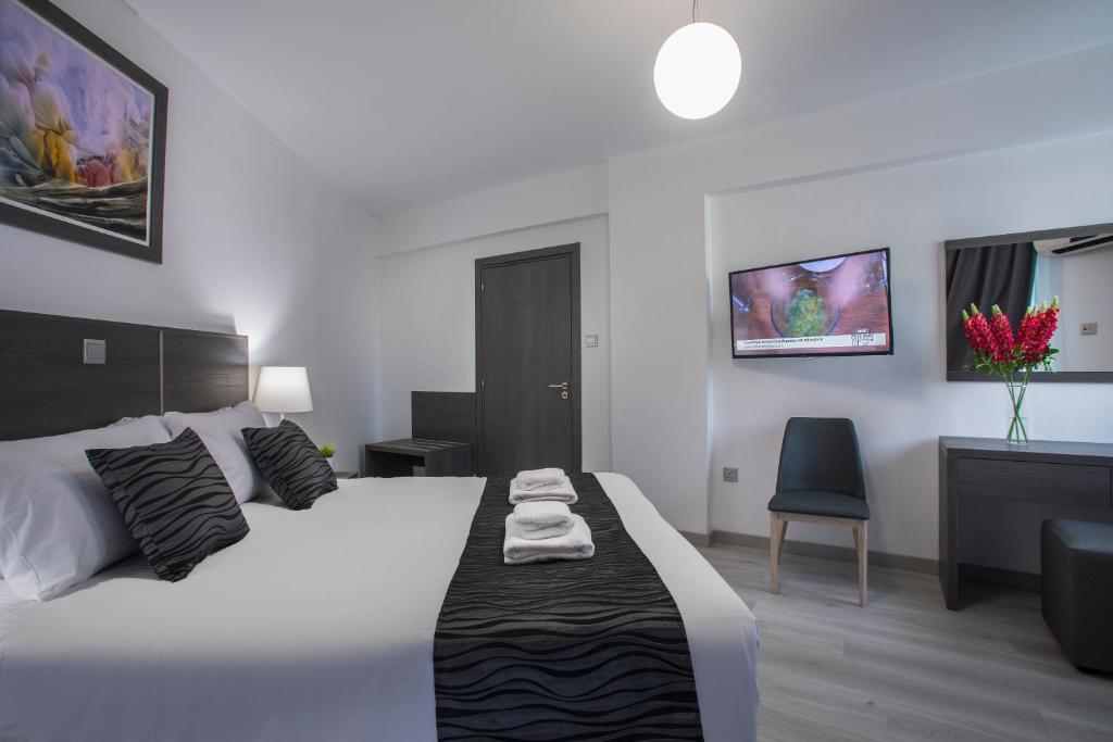 a bedroom with a white bed and a chair at Blazer Residence in Larnaka