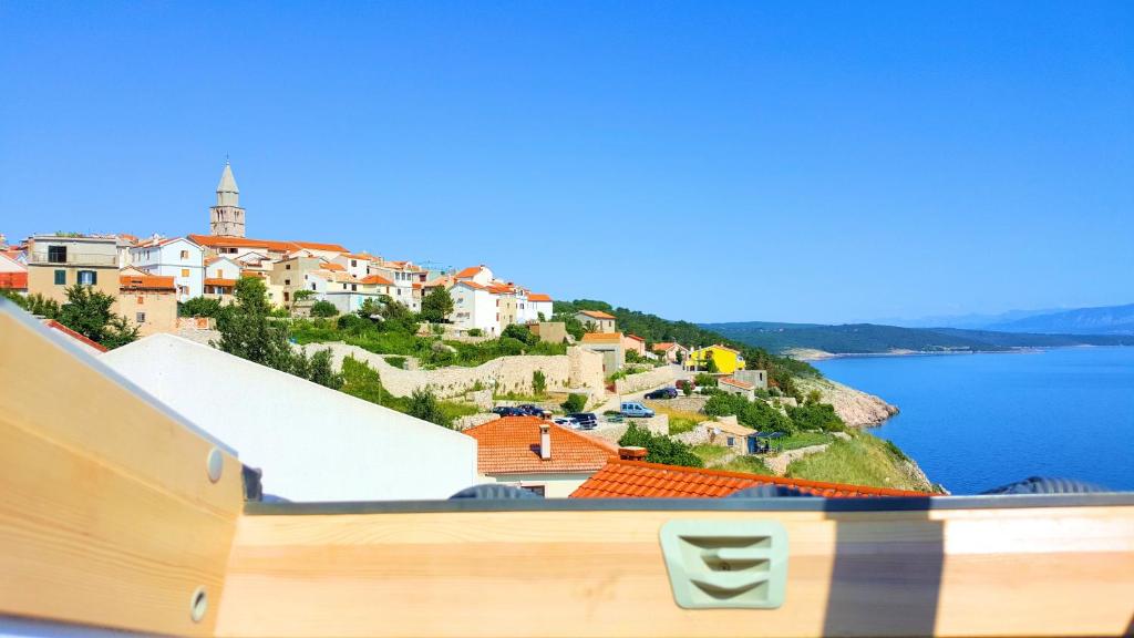 a view of a town on a hill next to the water at Apartment Vrbenka in Vrbnik