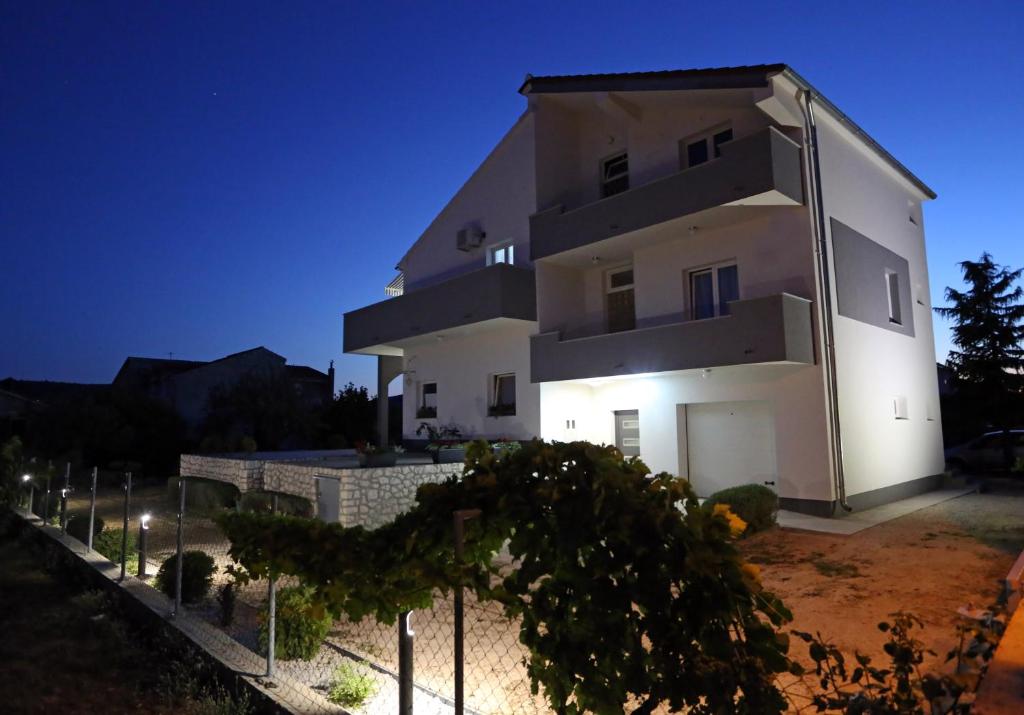 a large white building at night at Guesthouse Villa DomeNico in Lozovac