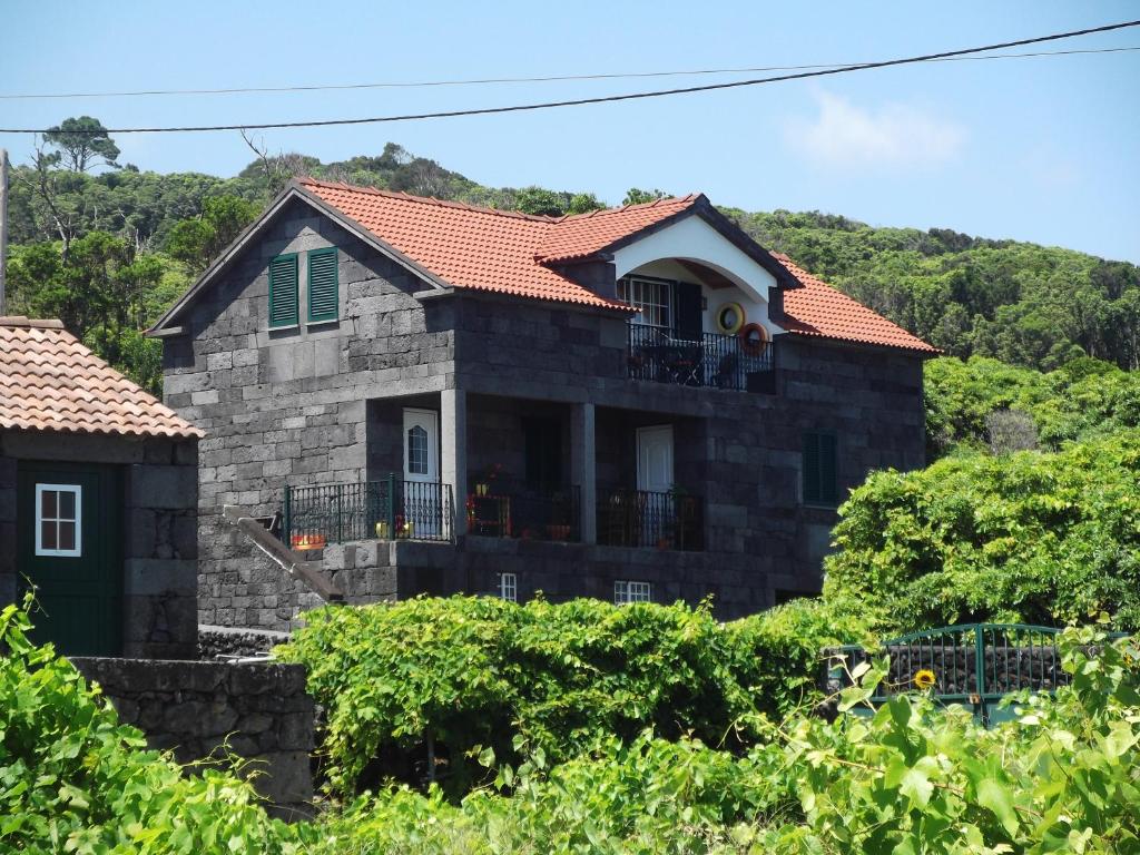 una casa de piedra con techo rojo en Grande Tranquilidade, en Prainha de Baixo