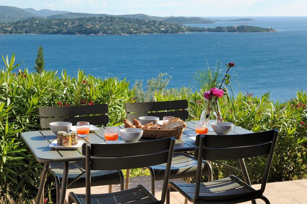 a table with chairs and a table with a view of the ocean at Mini villa Marina Serena in Porto-Vecchio