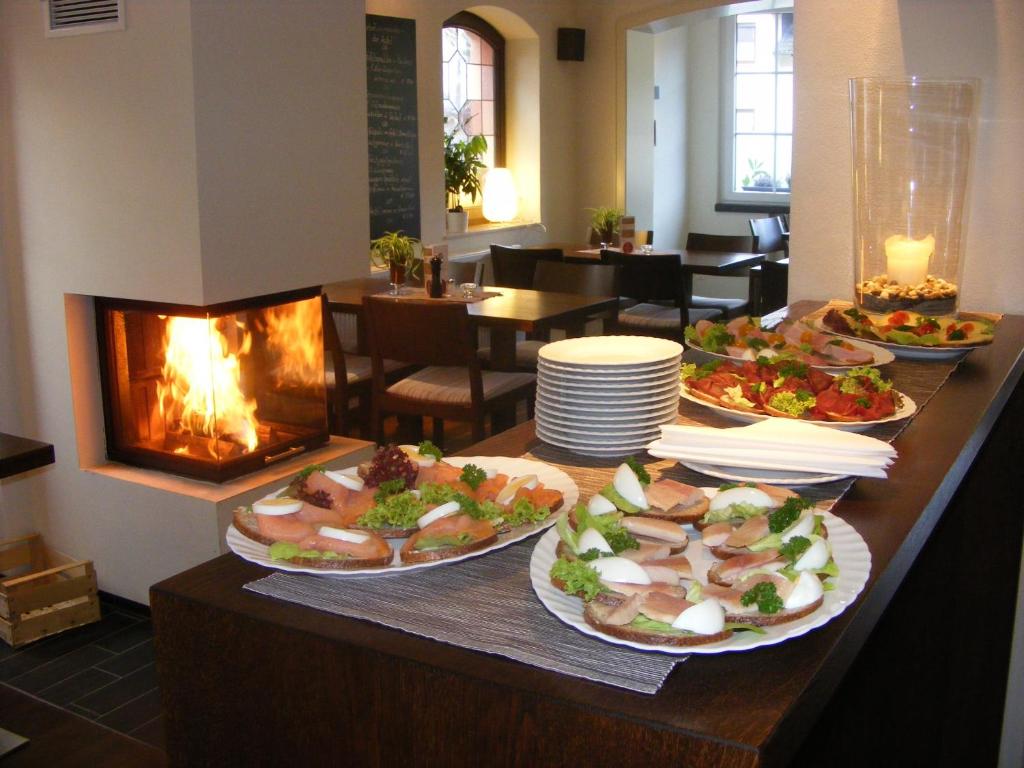 a buffet with several plates of food and a fireplace at Gästehaus Garni Sebastian 1520 in Rech