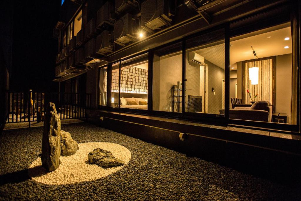 a building with windows and a statue on the ground at R&Run Kyoto Serviced Apartment & Suites in Kyoto