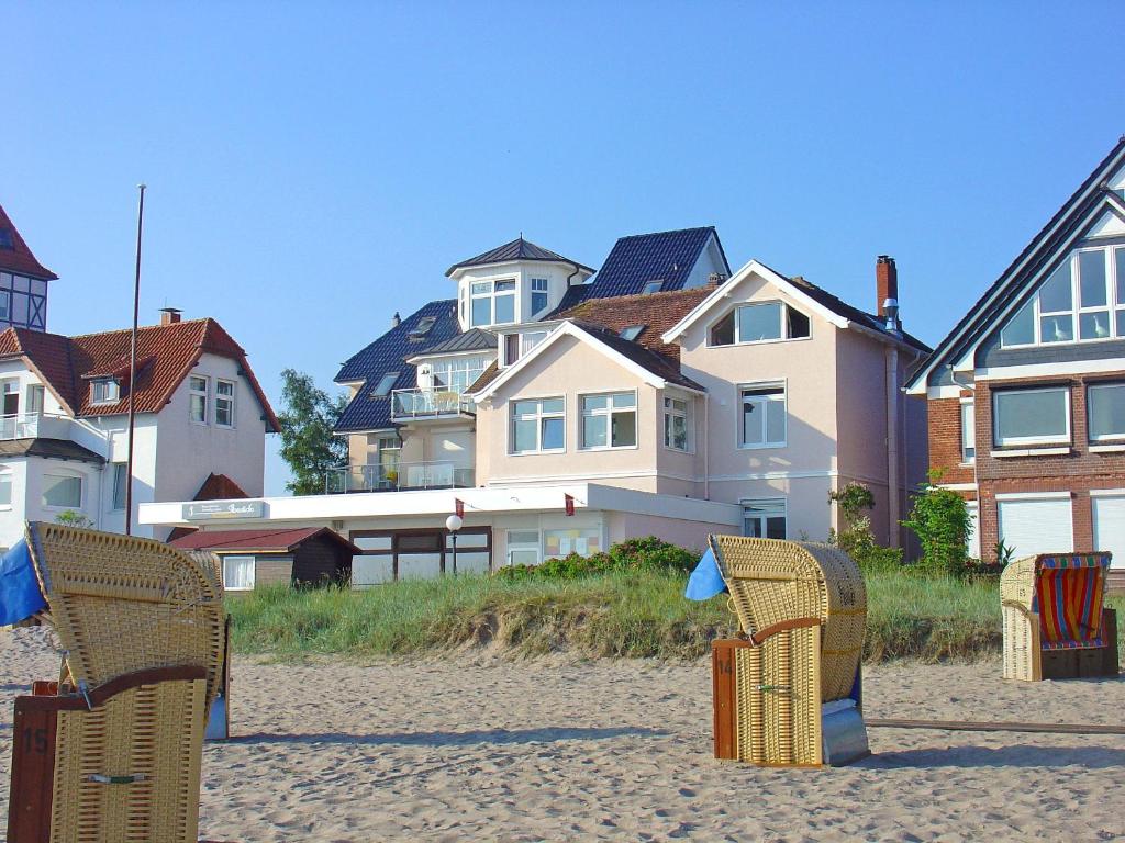 a group of chairs sitting on the beach at Strandhaus Brunhild in Timmendorfer Strand