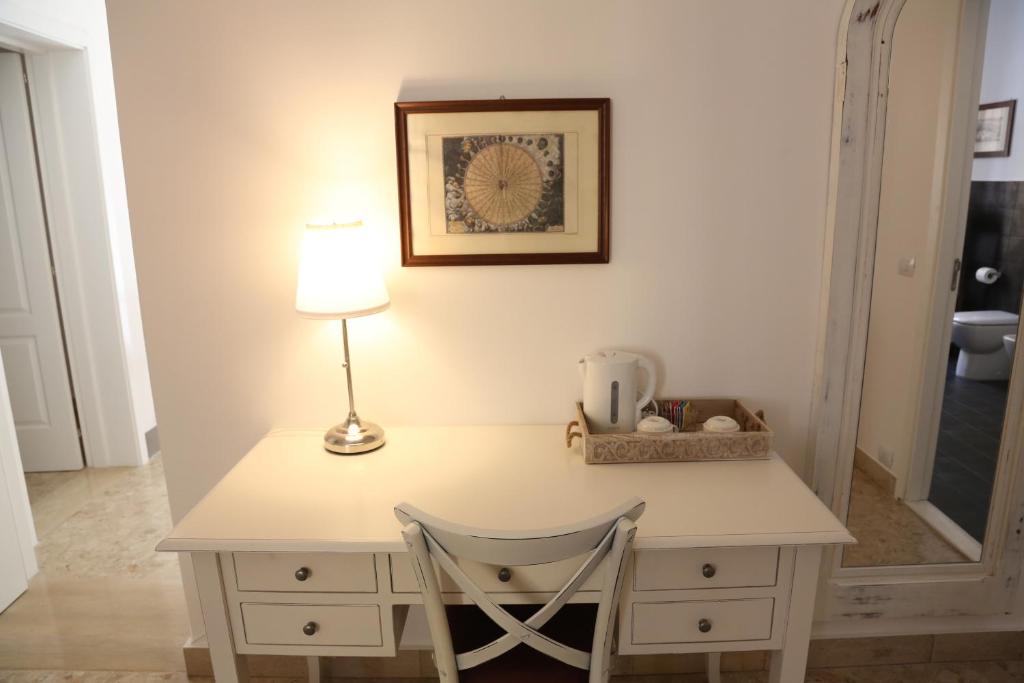 a desk with a lamp and a chair at Dimi House in Lecce